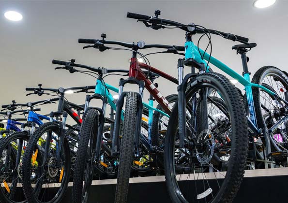 The showroom floor of The Bike Cellar in Plymstock, Trek 2026 stock in a tight line along the wall under the Trek-yellow signage.